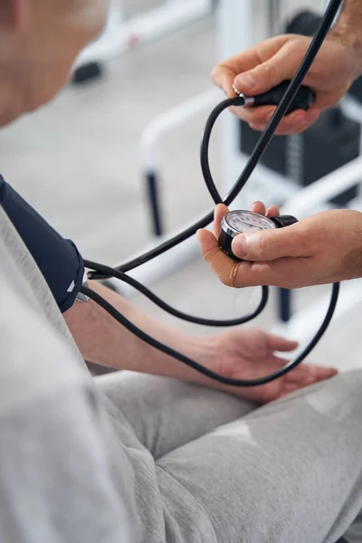 Läkarkontroller på blodtrycksmätare — Stockfoto