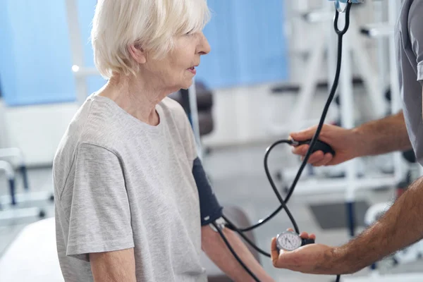 Oudere vrouwelijke patiënt die bloeddrukmeting ondergaat — Stockfoto