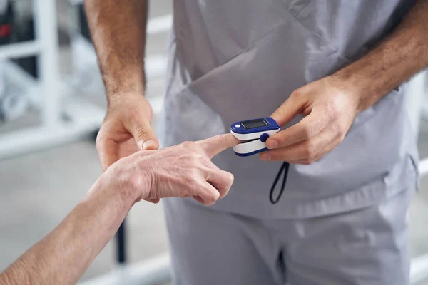 Γιατρός που χρησιμοποιεί ψηφιακό παλμικό οξύμετρο στο άκρο δακτύλου του ασθενούς — Φωτογραφία Αρχείου