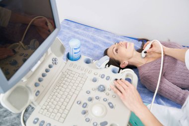 Genç hasta klinikte ultrason muayenesi yaptırıyor.