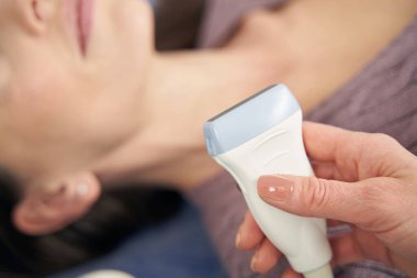 Doktor, teşhis için ultrasonik dönüştürücü kullanıyor.