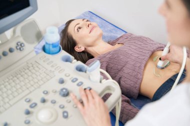 Klinikte karın ultrasonografisi çekilen kadın hasta.