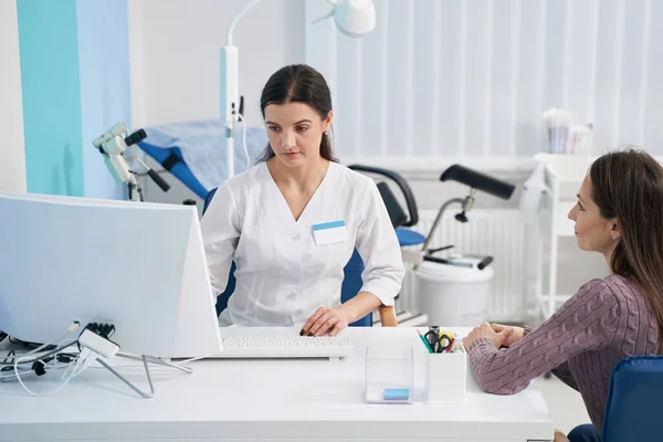 Fokussierte Ärztin erhält Kunden in ihrem Büro — Stockfoto