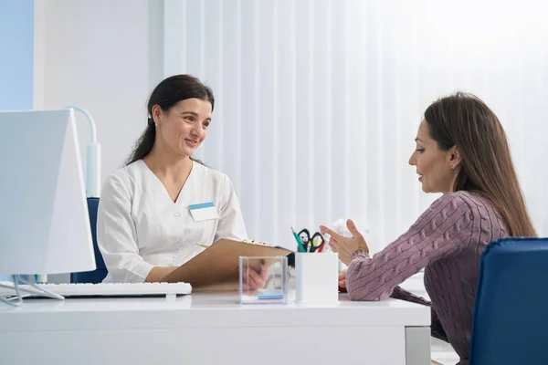 Concentrated attentive doctor conversing with her patient — Stock Photo, Image