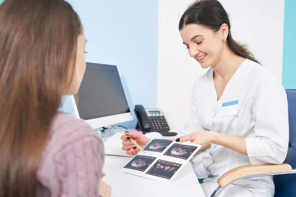 Glädjande läkare visar första trimestern foster ultraljud bilder till kvinnan — Stockfoto