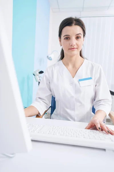 Tranquille jeune médecin assis au travail dans son bureau — Photo