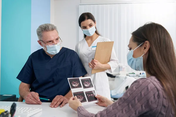 Mujer enfocada mirando imágenes de ultrasonido fetal después de la ecografía — Foto de Stock