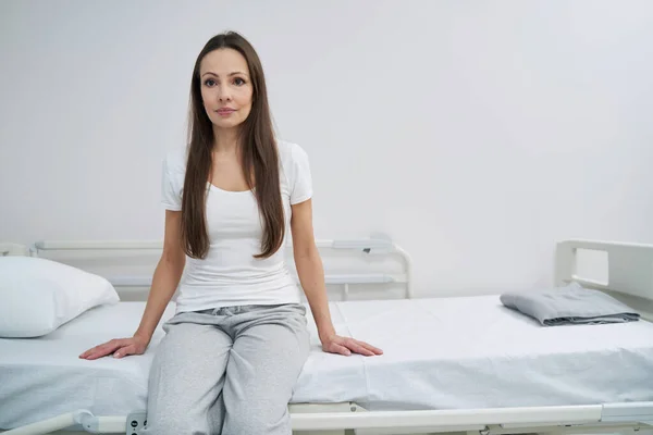 Pacjentka przygnębiona, siedząca sama na oddziale. — Zdjęcie stockowe