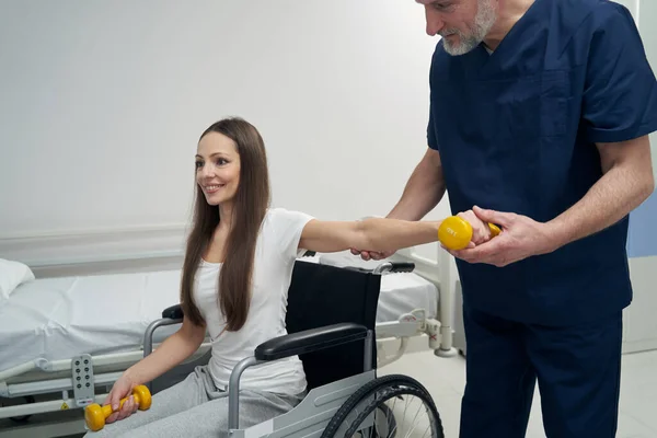 Joyeuse personne handicapée travaillant avec un physiothérapeute — Photo