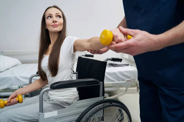 Mujer joven discapacitada sometida a sesión de fisioterapia con fisiatra calificado —  Fotos de Stock