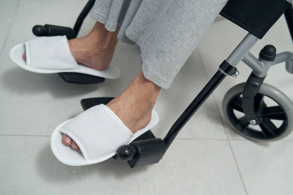 Persona con discapacidad en zapatillas sentada en silla de propulsión manual —  Fotos de Stock