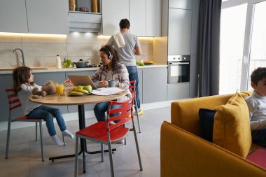 Dizüstü bilgisayarla çalışan ve kızına ulaşan bir kadın.