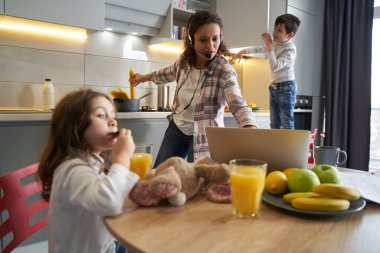 Yemek pişirirken dizüstü bilgisayarda yazan kadın