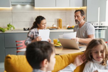 Mutfakta oturan evli çift çalışma kağıtlarıyla birlikte.