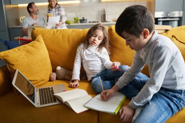 Çalışkan çocuk kanepede okul ödevi hazırlıyor.