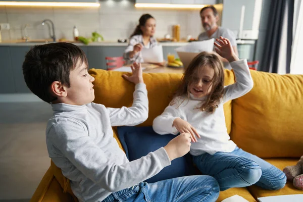 Niños pequeños jugando en el sofá en la cocina —  Fotos de Stock