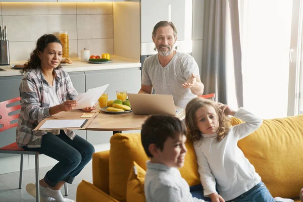 Önemseyen baba üzgün kızı kanepede rahatlatıyor.