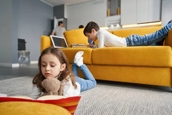 Niño con juguete oso lectura libro y niño escritura tarea —  Fotos de Stock