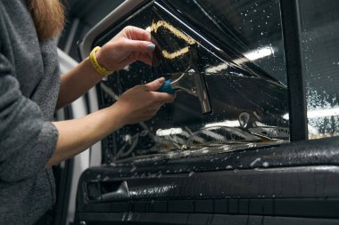 Cam yüzeyine jel püskürtülmüş PPF yapıştıran kadın