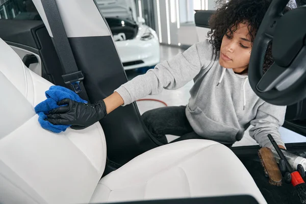 Focused detailer toweling down washed automotive seat — Stock Photo, Image