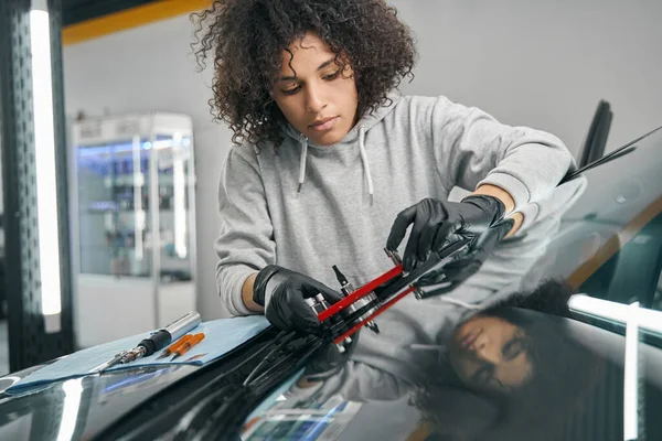 Allvarlig mekaniker installera bro för vindrutan innan injicera harts — Stockfoto