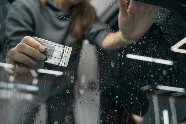 Skilled service station worker fixing PPF on windscreen — Stock Photo, Image