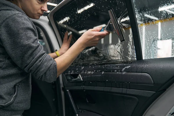 Detailer aplicando PPF pulverizado com gel de instalação para janela do carro — Fotografia de Stock