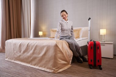 Bir kadın otel odasında eğleniyor.