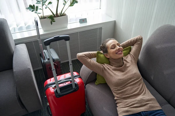Zadowolona kobieta relaksująca się sama w pokoju hotelowym — Zdjęcie stockowe