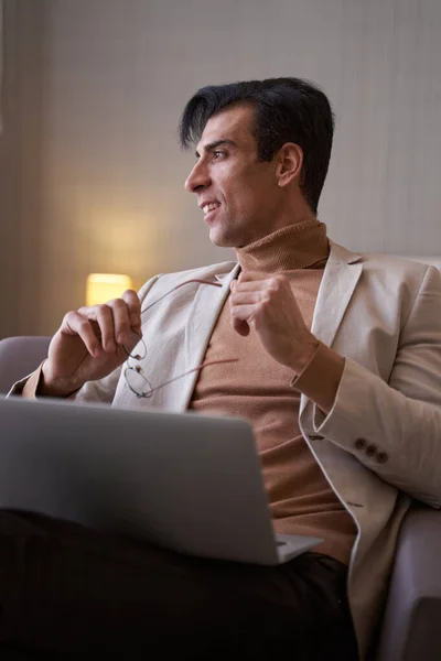 Pleased dreamy stylish male with laptop looking away — Stock Photo, Image