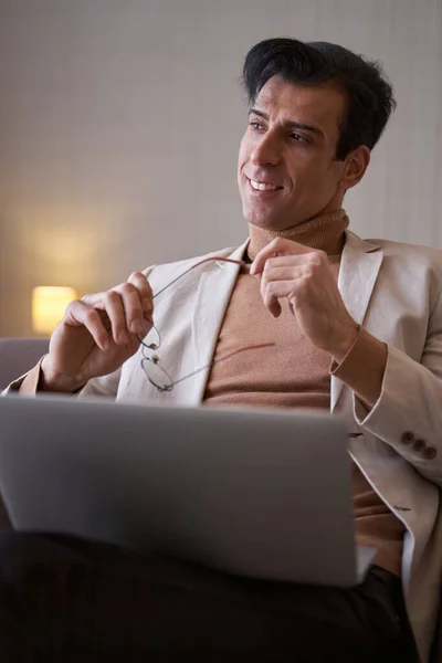 Dreamy elegant man with his portable computer sitting indoors — Stock Photo, Image