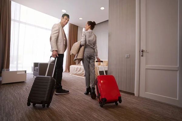 Loving couple with baggage in hotel room — Stock Photo, Image