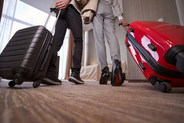 Hombre y mujer con equipaje en habitación de hotel — Foto de Stock