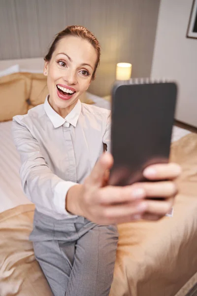 Zâmbind veselă femeie turist luând selfie-uri în apartamentul ei de lux — Fotografie, imagine de stoc
