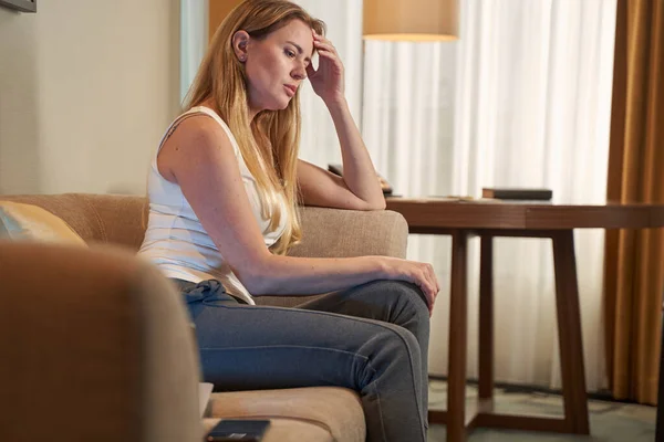 Traurige Frau denkt auf dem Sofa an ihre Probleme — Stockfoto