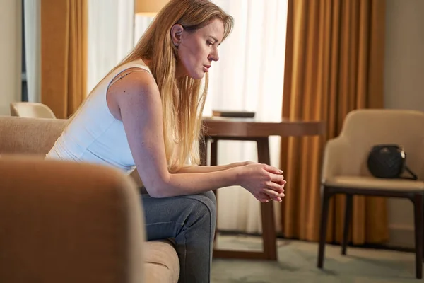 Troubled junge Dame in Tank Top sitzt auf Couch — Stockfoto