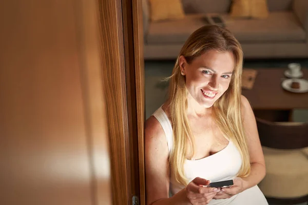 Joyful woman looking up from bookreader into camera and smiling — Stock Photo, Image