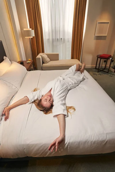 Žena protahuje záda, zatímco odpočívá na posteli — Stock fotografie