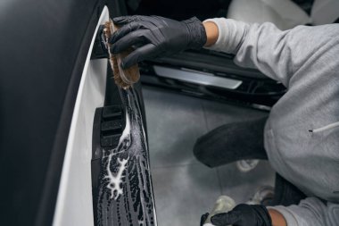 Deneyimli servis çalışanı müşteri aracını temizliyor
