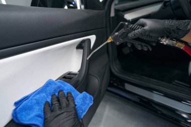 Otomotiv iç yüzeyi üzerinde pnömatik araç kullanan servis çalışanı