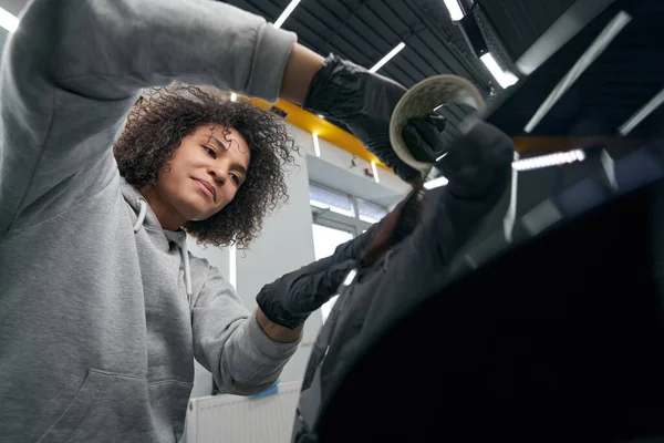 Geconcentreerde werknemer tankstation kiezen auto polijsten tool — Stockfoto