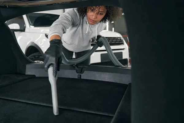 Focused young worker vacuum-cleaning interior of automobile — Stock Photo, Image