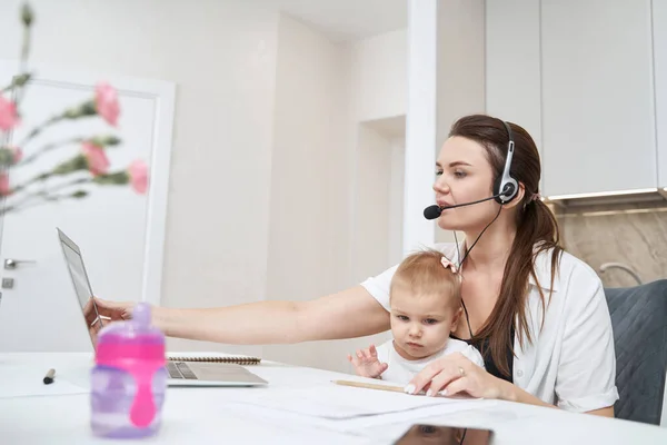 Female opening laptop screen with baby on her knees — Stock Photo, Image