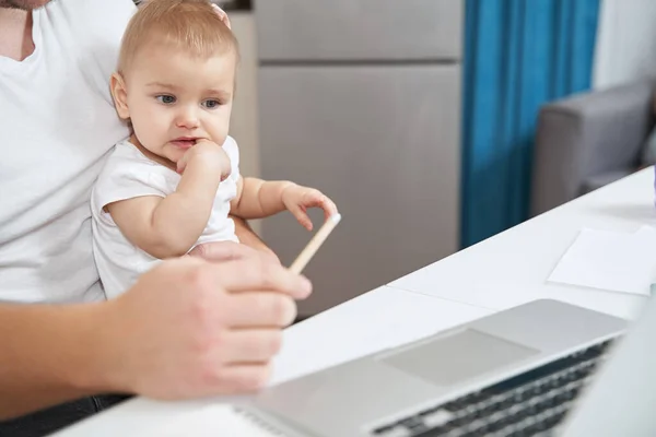 Child picking its mouth while looking at laptop — Stock Photo, Image