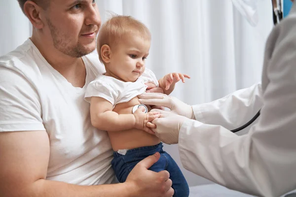 Médico escuchando a un niño respirar a través del estetoscopio — Foto de Stock