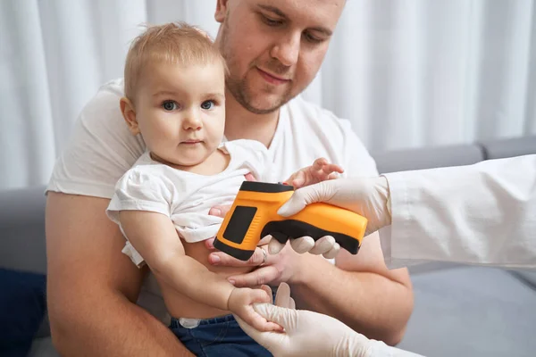 Sanitäter mit berührungslosen Thermometern an Kinderhand — Stockfoto