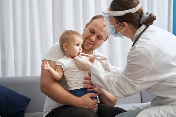 Arzt benutzt Zungendepressor, um Babykehle zu kontrollieren — Stockfoto