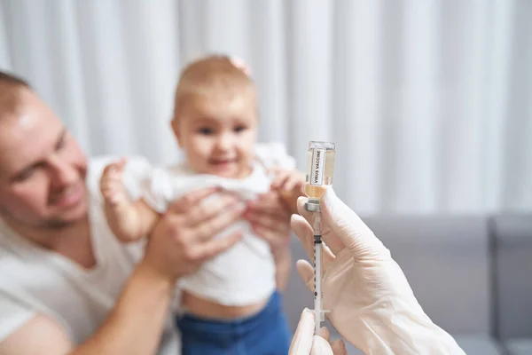 Médico recibiendo la vacuna contra el virus en la jeringa de la ampolla — Foto de Stock