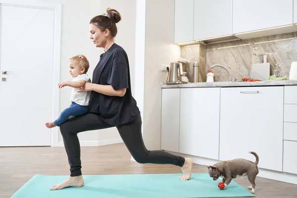 Mujer haciendo embestida lateral con niño en las manos —  Fotos de Stock