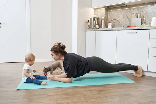 Mor stirrar på ungen under träning nära hund med boll — Stockfoto